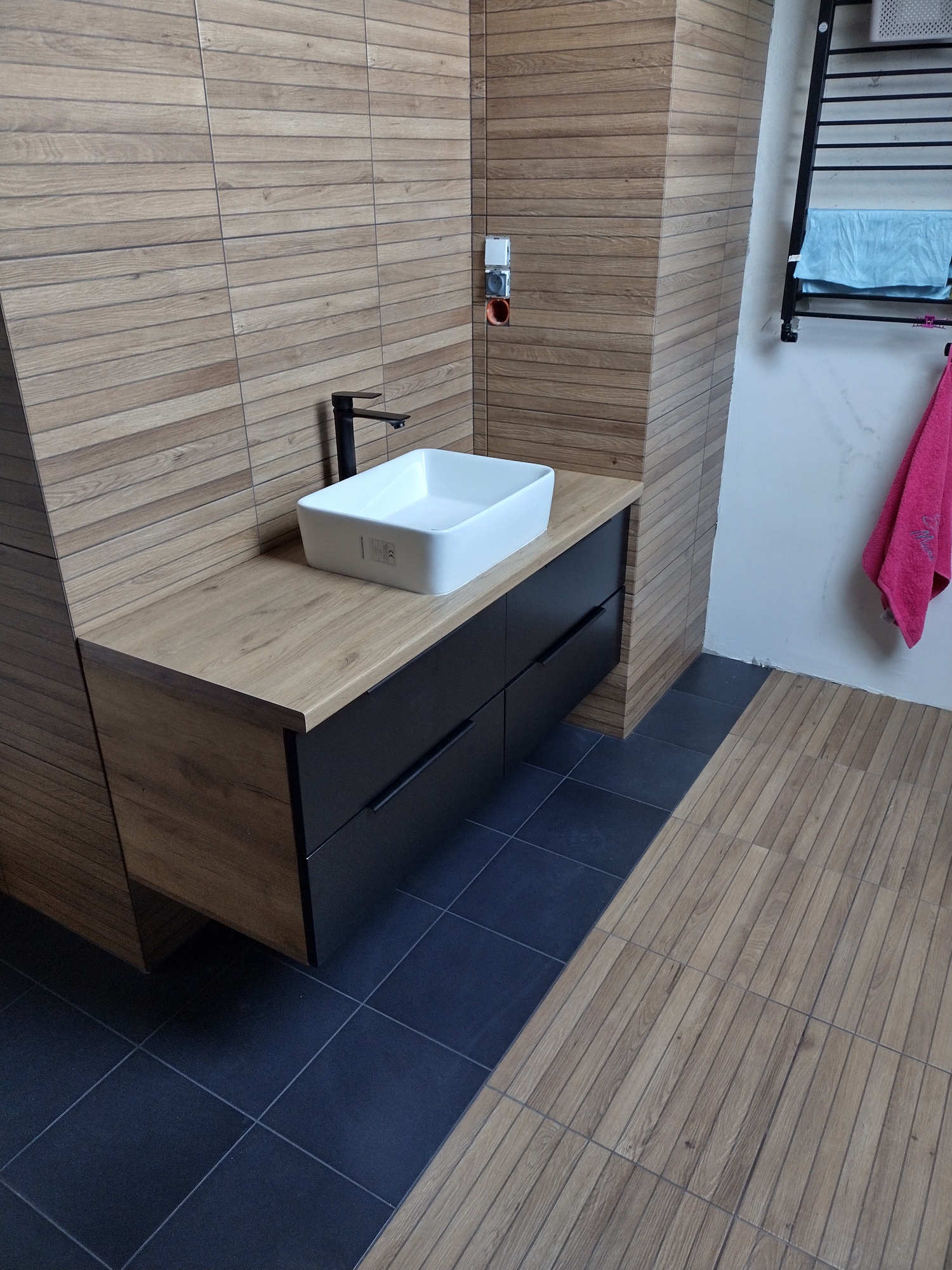 Łazienka z czarną szafką wiszącą